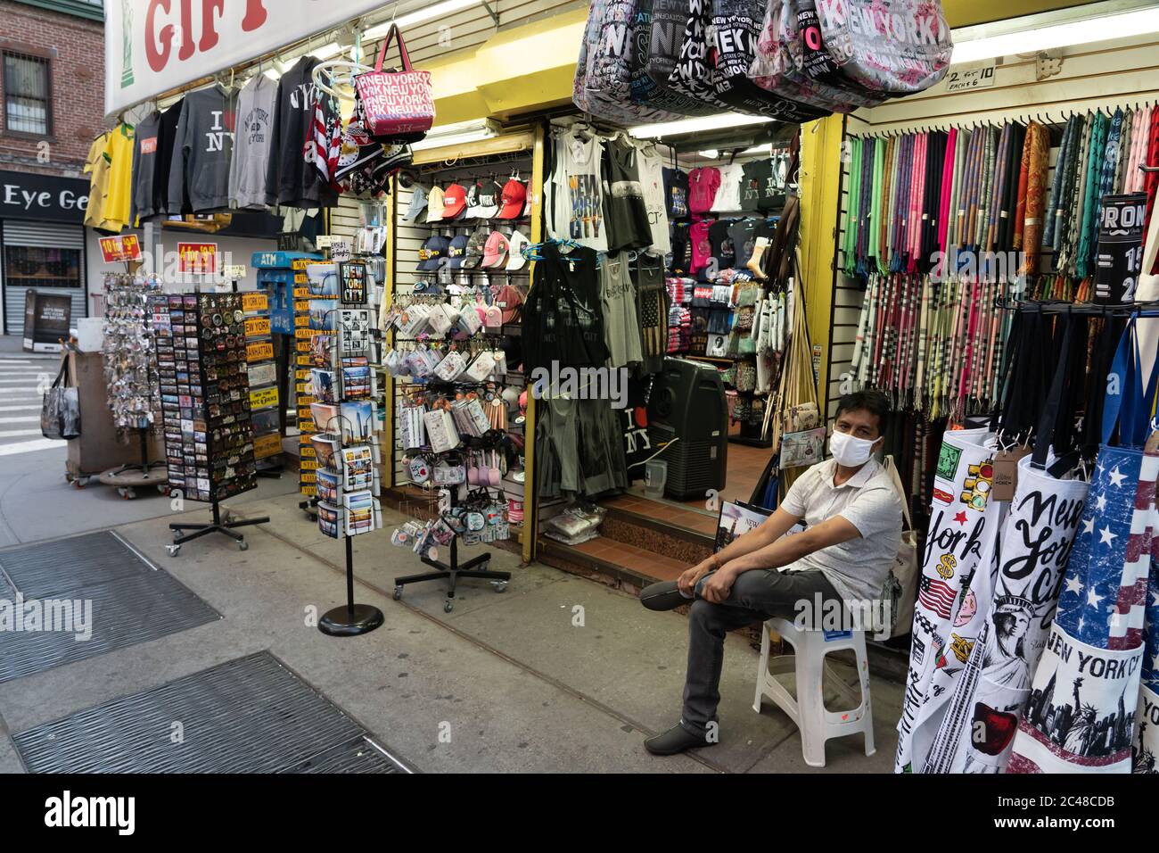 NEW YORK, NY - 24 GIUGNO 2020: Un custode di souvenir si trova di fronte a un negozio vuoto a Chinatown di Manhattan il 24 giugno 2020 a New York City. Foto Stock