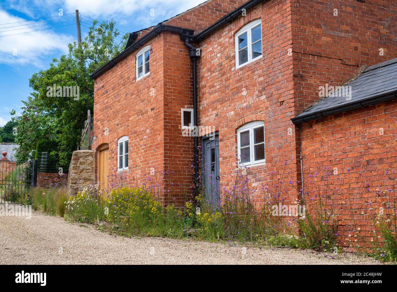 Case in mattoni rossi e fiori. Upper Brailes, Warwickshire, Inghilterra Foto Stock