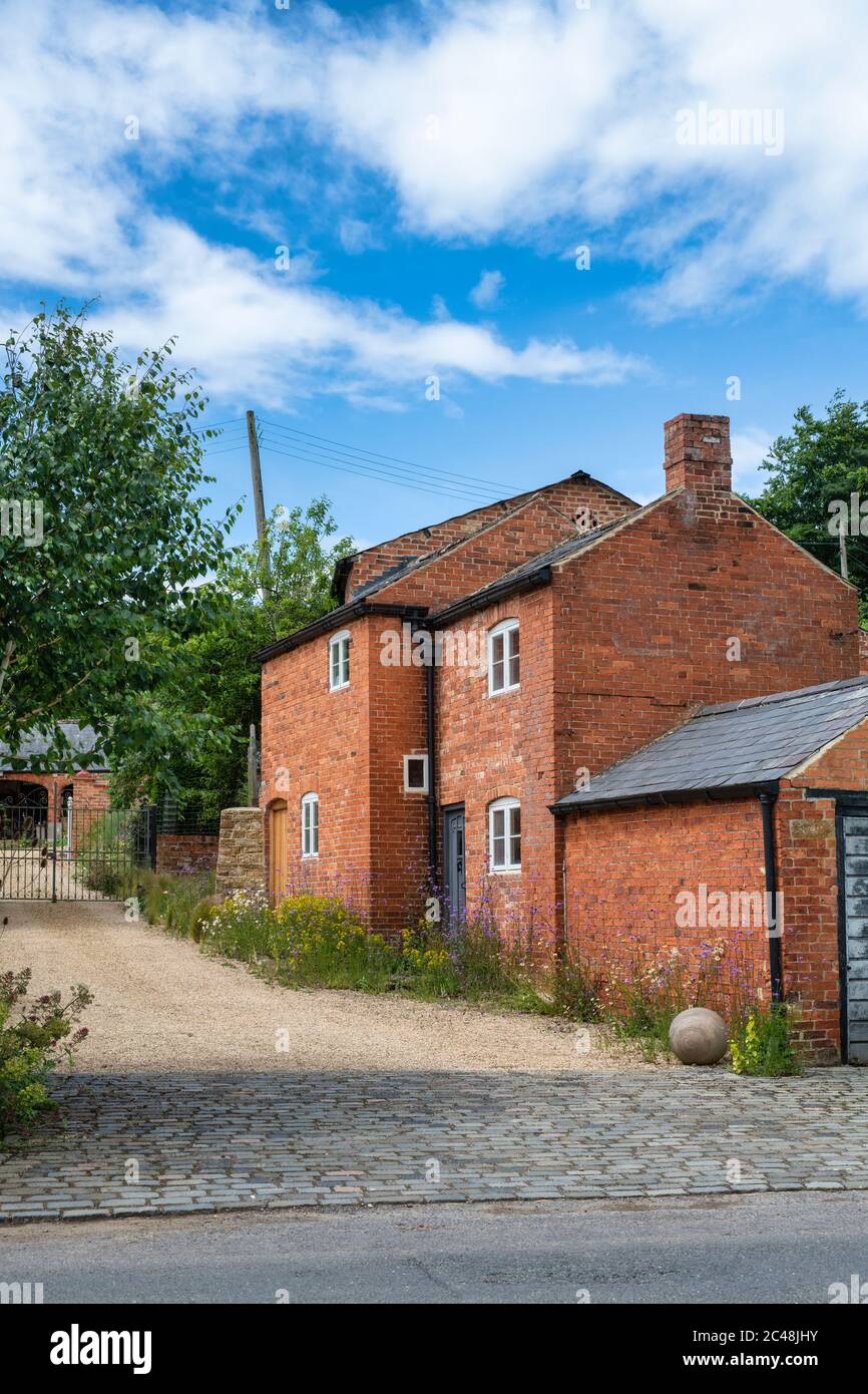 Case in mattoni rossi e fiori. Upper Brailes, Warwickshire, Inghilterra Foto Stock