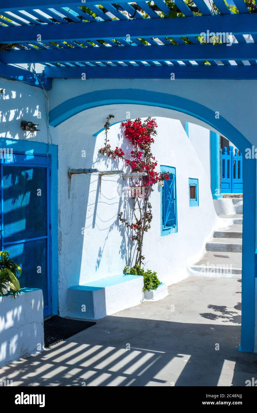 Architettura greca tradizionale con pareti bianche e accenti blu, in un villaggio sull'isola di Santorini. Foto Stock