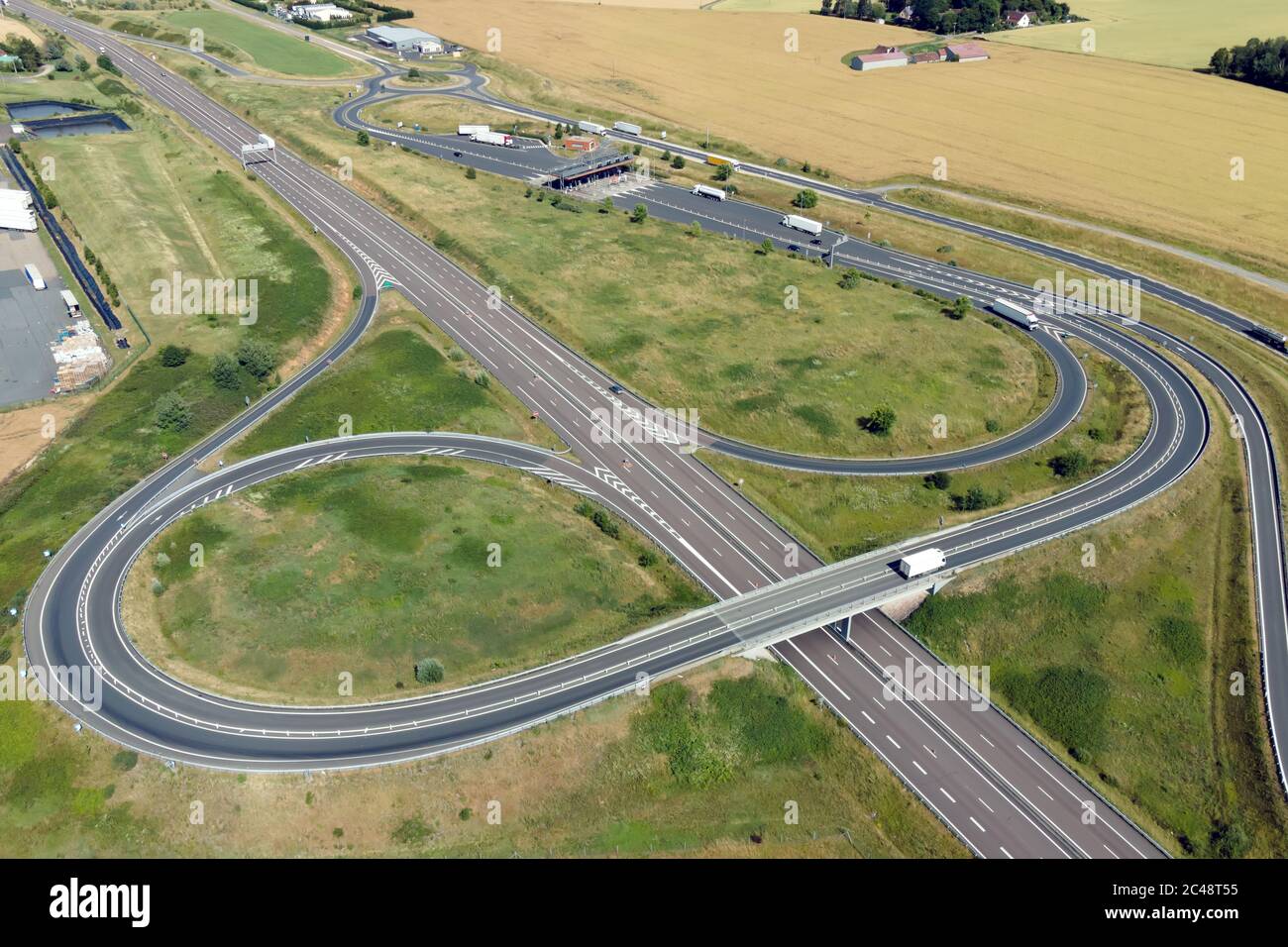 Vista aerea di uno svincolo autostradale e di una stazione a pedaggio in Francia Foto Stock