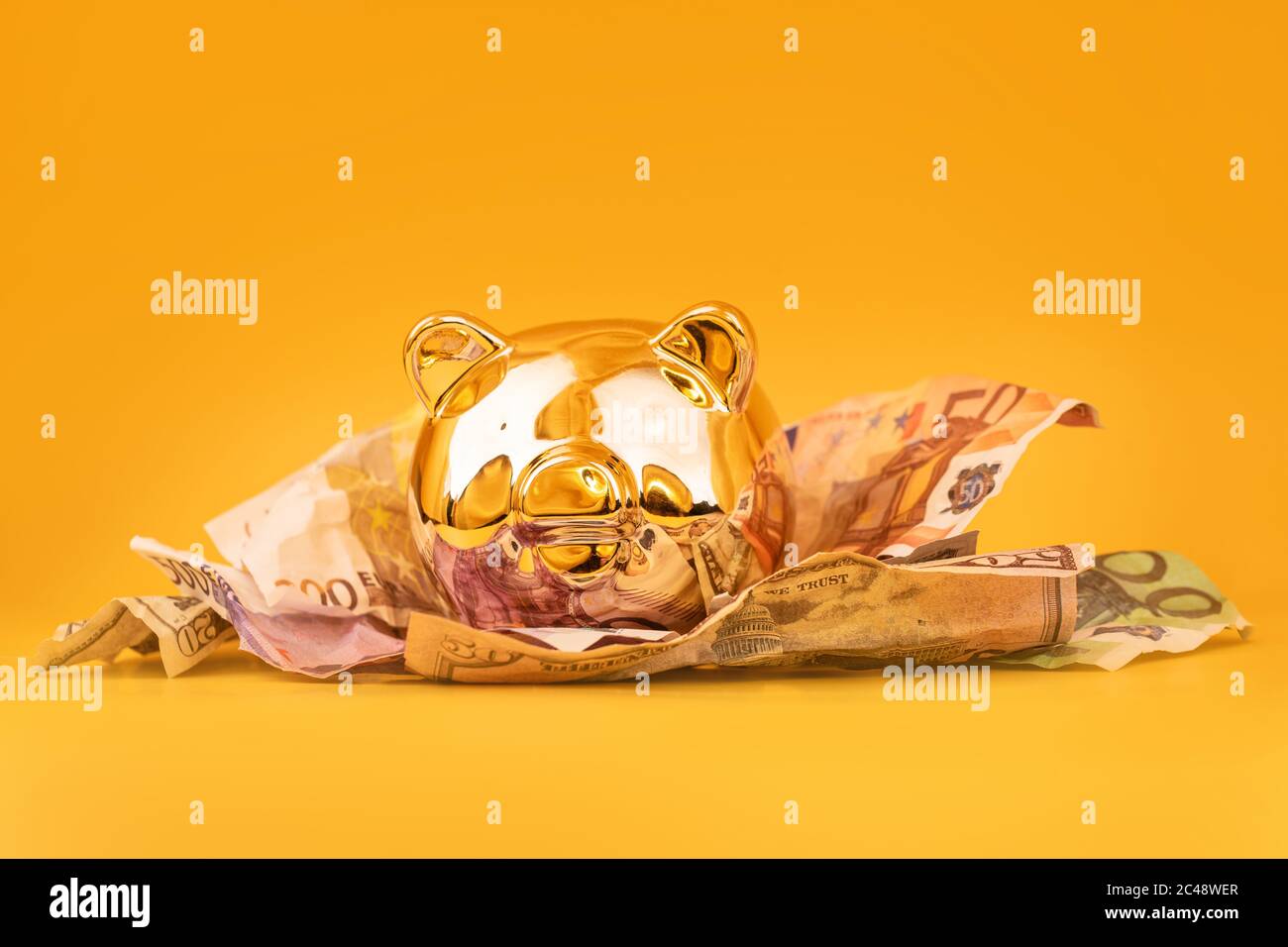 Golden piggy banca con denaro contante, euro e banconote in dollari. Scatola di soldi d'oro, risparmi enormi, accumulazione di soldi. Denaro maiale, risparmio di denaro, Moneybox Foto Stock