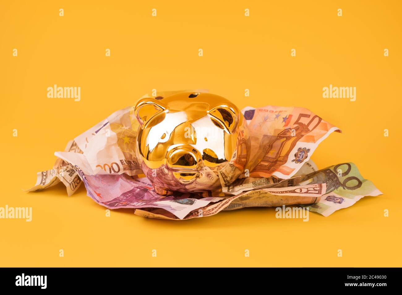 Golden piggy banca con denaro contante, euro e banconote in dollari. Scatola di soldi d'oro, risparmi enormi, accumulazione di soldi. Moneypig, risparmio di denaro, Moneybox Foto Stock