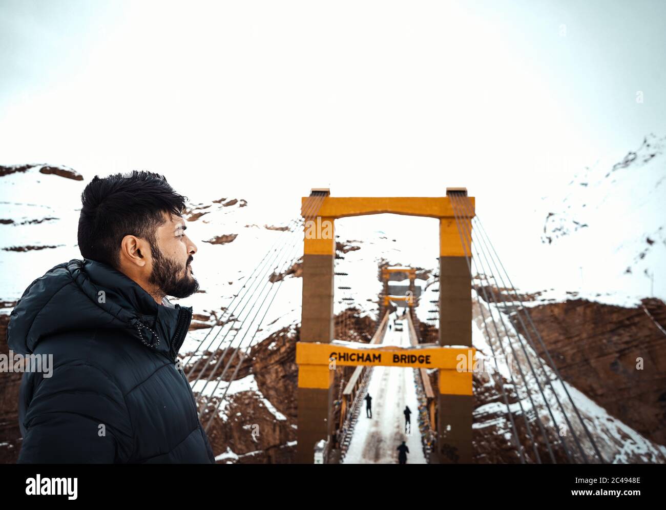 Giovane uomo vicino al ponte di Chicham in India in inverno Foto Stock