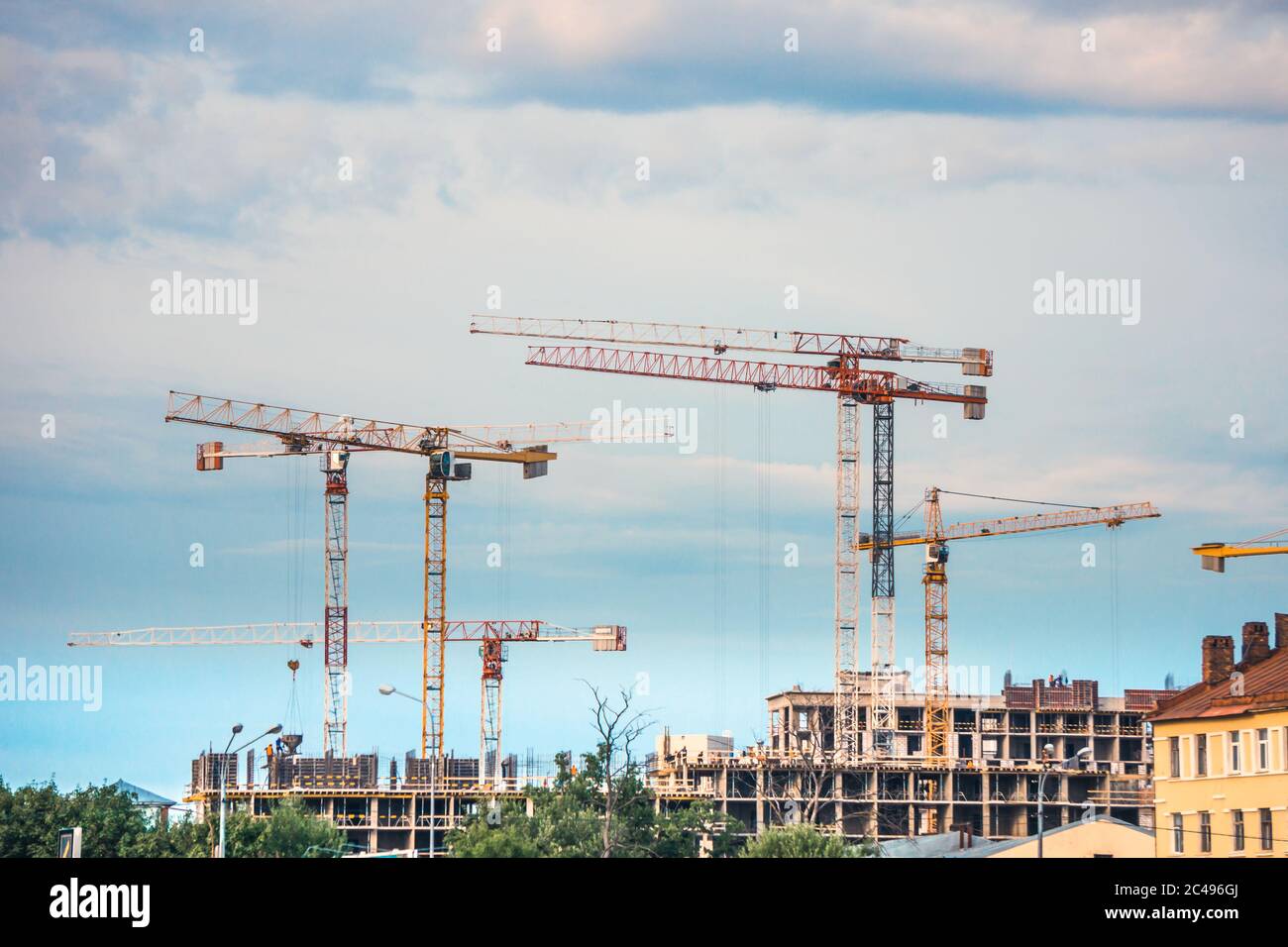 Gru industriali per edilizia operanti in cantiere, sviluppo di edifici residenziali Foto Stock