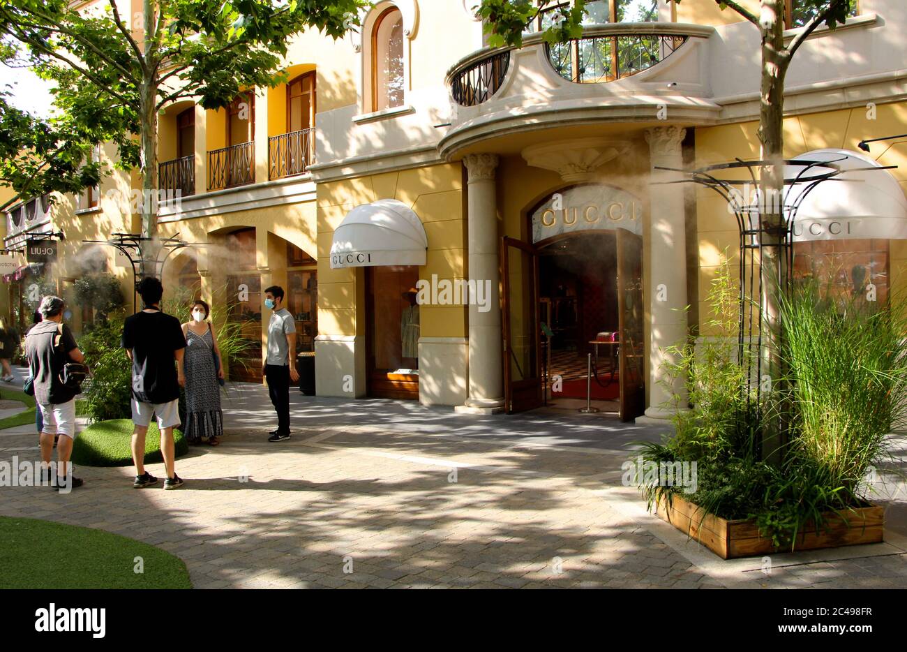 Centro commerciale outlet Las Rozas Madrid Spagna con raffreddamento umidificante Spruzzi d'acqua dalle bocchette nelle zone pedonali vicino a Gucci negozio Foto Stock