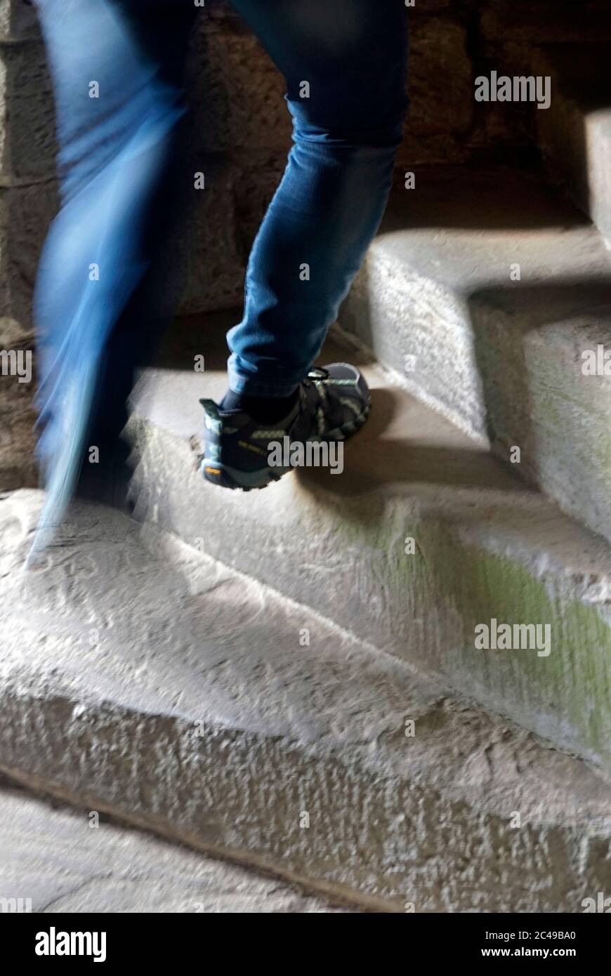 uomo che sale scale di pietra nel castello Foto Stock