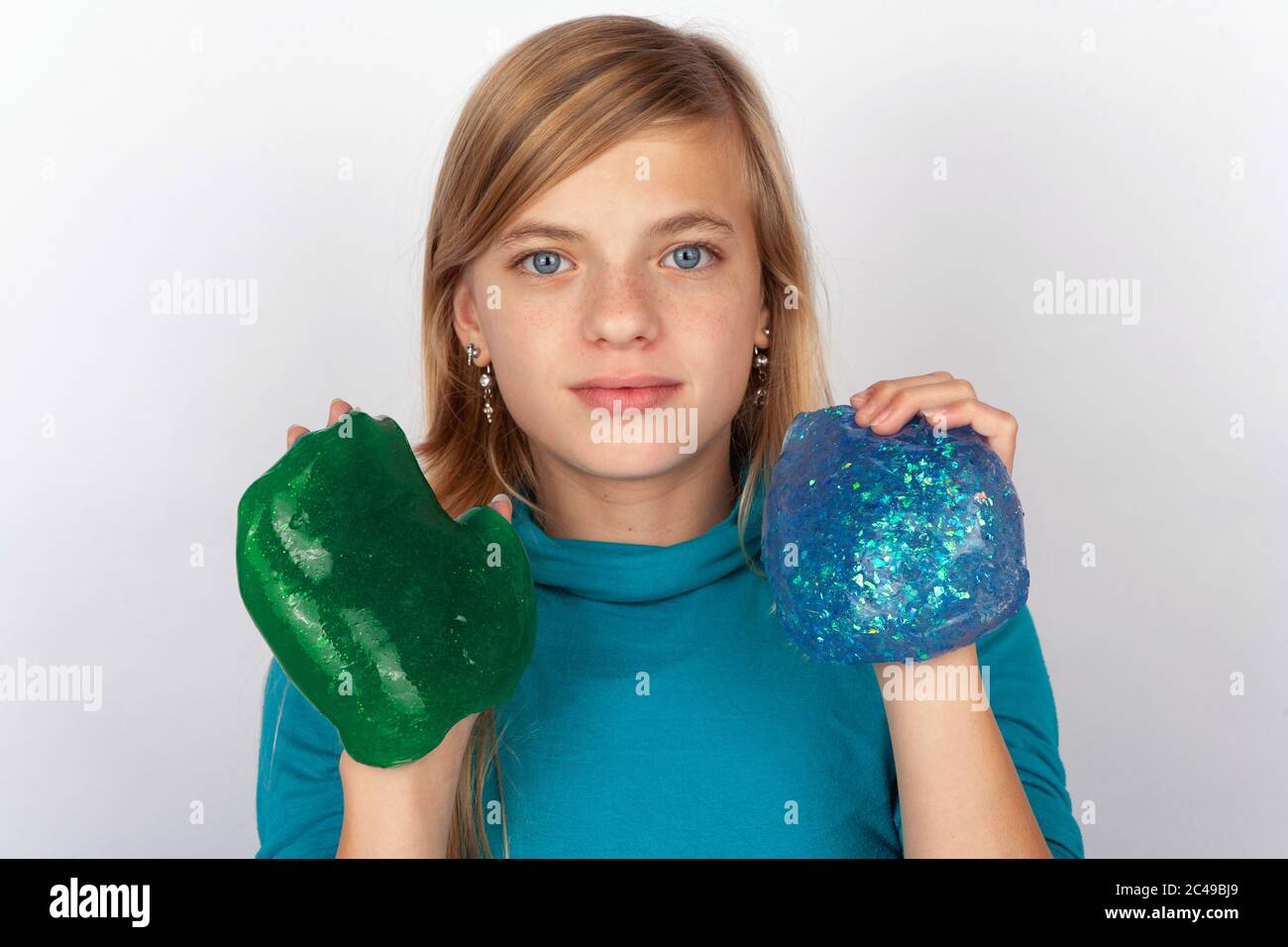 Giovane ragazza che mostra un verde e un blu scimoso Foto Stock