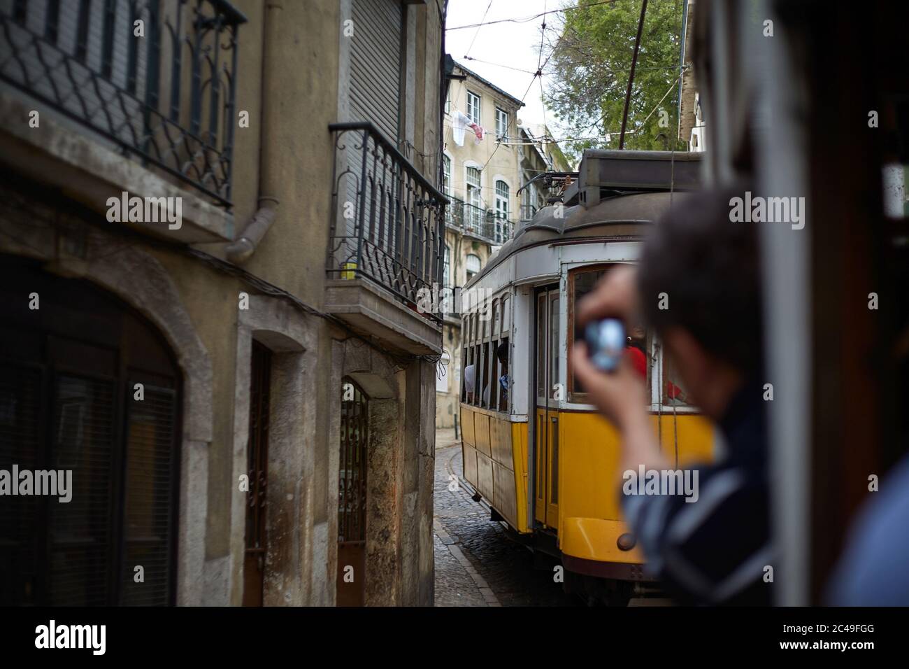 Persona che scatta foto di un tram giallo in Spagna Foto Stock