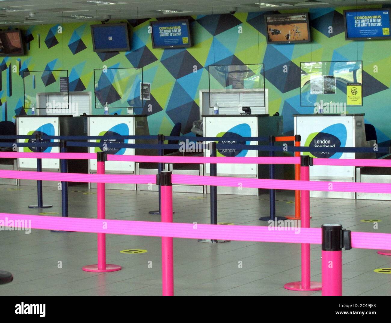 L'aeroporto di Londra Southend ha reso sicuro il loro terminal building Covid-19 nel giugno 2020, posizionando schermi di vetro perspex nella zona di check-in con consegna dei bagagli Foto Stock