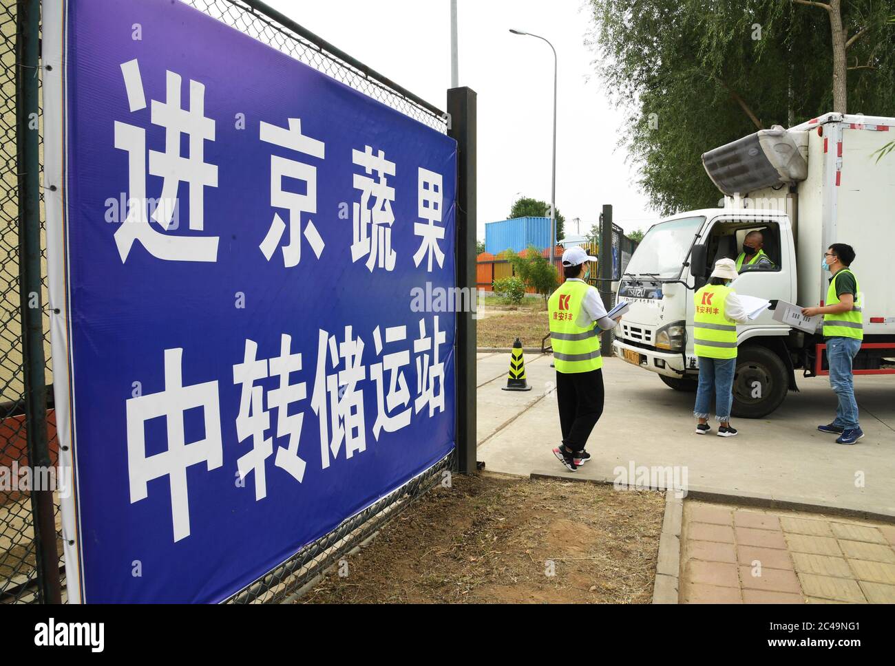 (200625) -- PECHINO, 25 giugno 2020 (Xinhua) -- personale registra le informazioni di un autista di camion e del suo veicolo all'entrata del Pinggu Mafang trasferimento di deposito e stazione di trasporto per frutta e verdura che entra a Pechino nel distretto di Pinggu, Pechino, capitale della Cina, 25 giugno 2020. La stazione di stoccaggio e trasporto dei trasferimenti, che comprende l'area di disinfezione, l'area di turnover, l'area di stoccaggio temporaneo e l'area di gestione chiusa, è stata recentemente messa in uso. La capacità di trasporto dei camion può raggiungere oltre 50 veicoli e il volume di transito giornaliero di frutta e verdura Foto Stock
