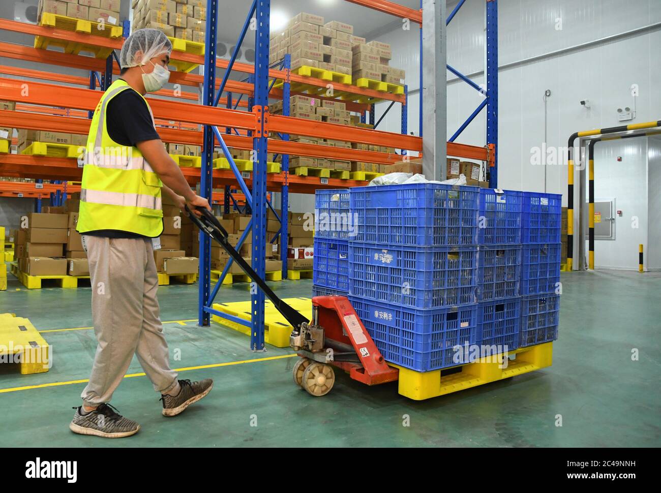 (200625) -- PECHINO, 25 giugno 2020 (Xinhua) -- UN membro dello staff trasferisce le verdure al magazzino di conservazione di Pinggu Mafang trasferimento di stoccaggio e stazione di trasporto per frutta e verdura che entra a Pechino nel distretto di Pinggu, Pechino, capitale della Cina, 25 giugno 2020. La stazione di stoccaggio e trasporto dei trasferimenti, che comprende l'area di disinfezione, l'area di turnover, l'area di stoccaggio temporaneo e l'area di gestione chiusa, è stata recentemente messa in uso. La capacità di trasporto dei camion può raggiungere oltre 50 veicoli e il volume di transito giornaliero di frutta e verdura può raggiungere più di un Foto Stock