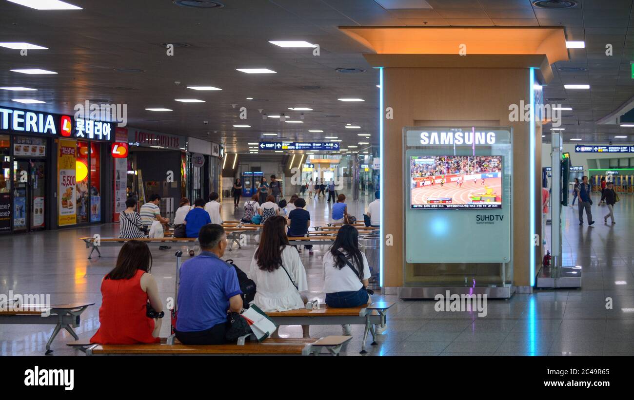 Seoul, Corea del Sud - la gente guarda le notizie televisive nella sala d'attesa della stazione di Seoul. Stazione ferroviaria principale. Televisione sponsorizzata da Samsung. Foto Stock