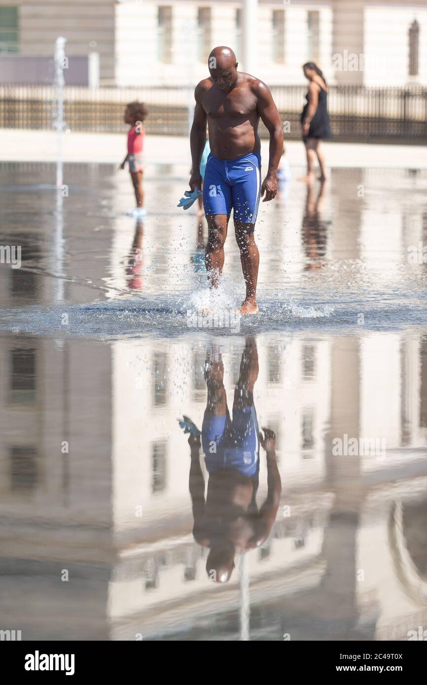 Uomo nero che cammina in acque poco profonde, Centenary Square, Birmingham UK Foto Stock