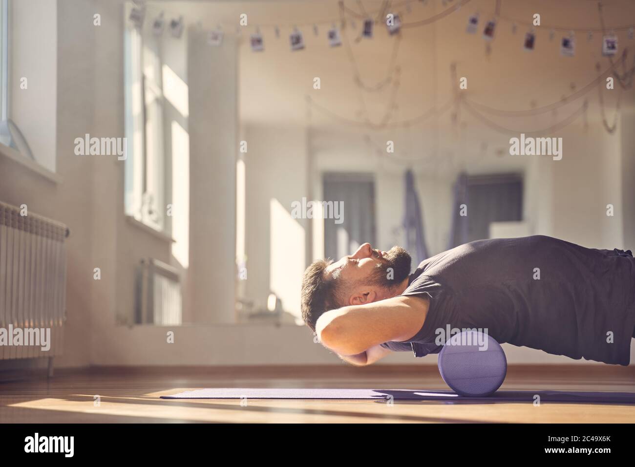 Uomo bearded giacente sul rullo di schiuma durante l'addestramento in studio Foto Stock