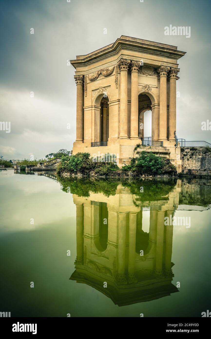 La torre del serbatoio Château d'eau du Peyrou si riflette in acqua. Fa parte della Promenade du Peyrou, un parco all'interno di Montpellier. Foto Stock