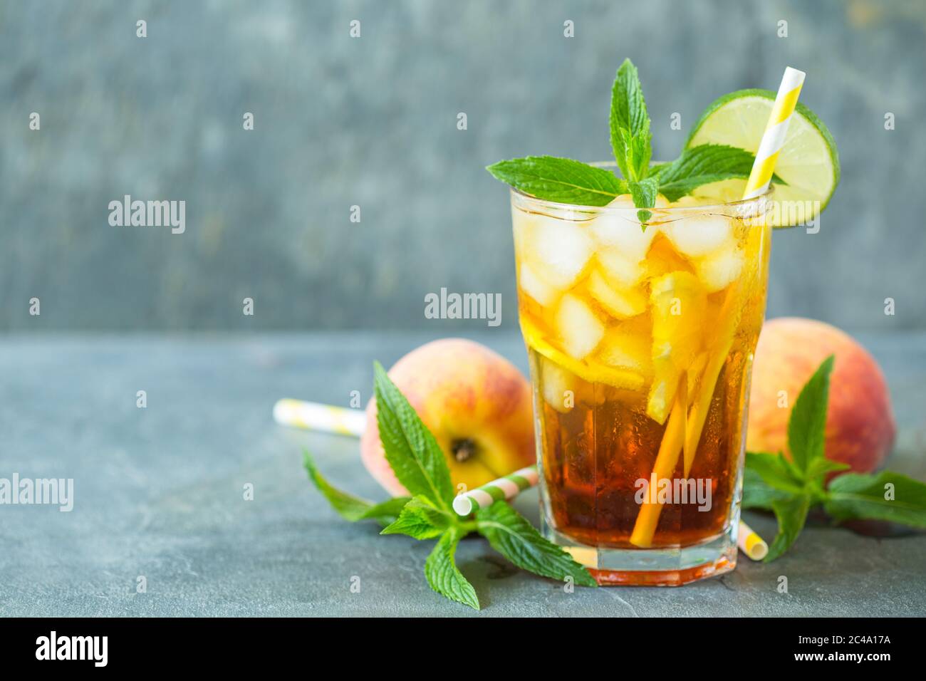 Tè fatto in casa con ghiaccio di pesca, lime e menta nel bicchiere Foto Stock
