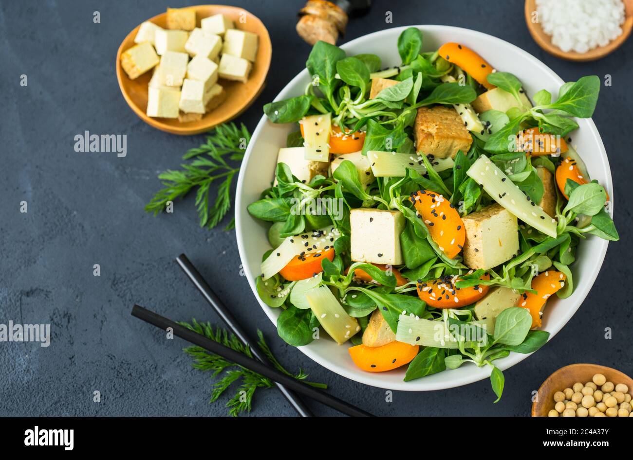 Insalata di tofu fresca con semi di sesamo, insalata di mais, albicote e bambù nel recipiente Foto Stock