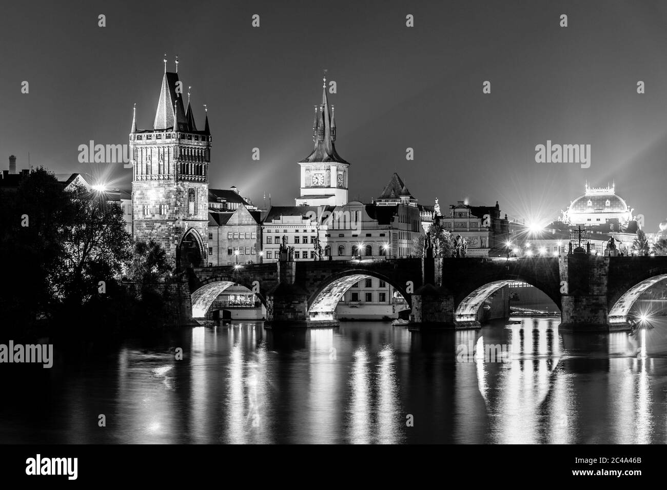 Moldava River e Ponte Carlo con la Torre del Ponte della Citta' Vecchia di notte, Praga, Cechi. Sito patrimonio dell'umanità dell'UNESCO. Immagine in bianco e nero. Foto Stock