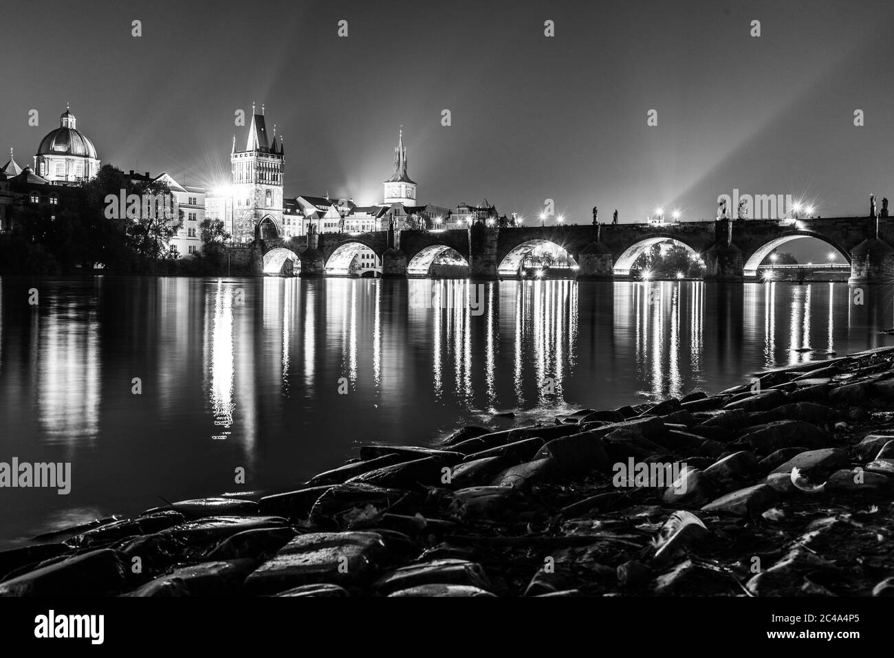Moldava River e Ponte Carlo con la Torre del Ponte della Citta' Vecchia di notte, Praga, Cechi. Sito patrimonio dell'umanità dell'UNESCO. Immagine in bianco e nero. Foto Stock