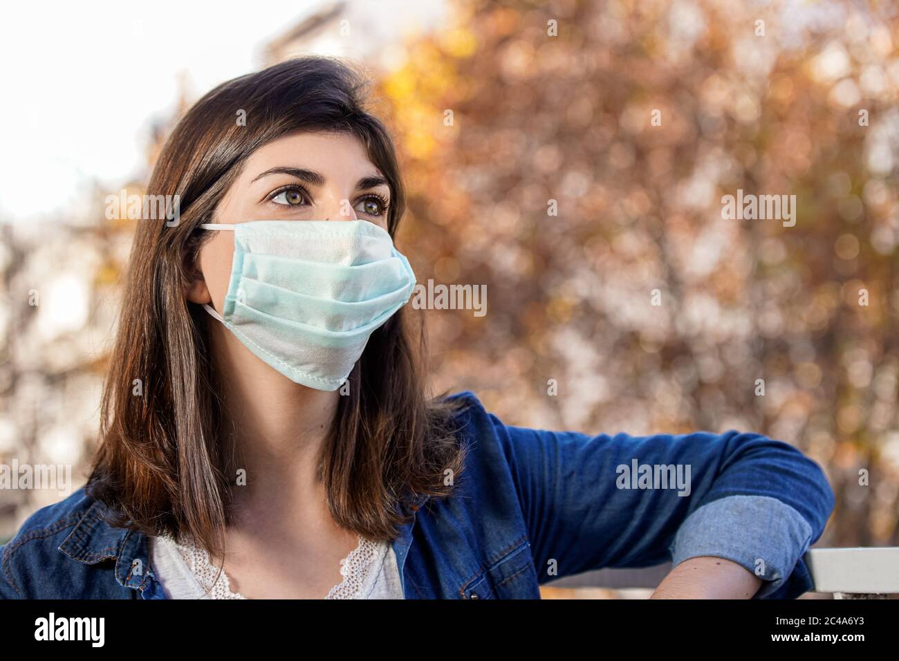 Primo piano ritratto di una donna all'aperto che indossa una maschera di protezione medica Foto Stock