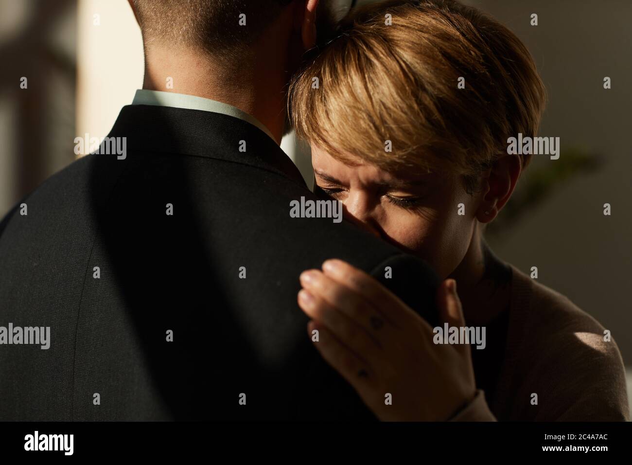 Donna triste che abbracciava l'uomo e la sostiene in una situazione difficile Foto Stock