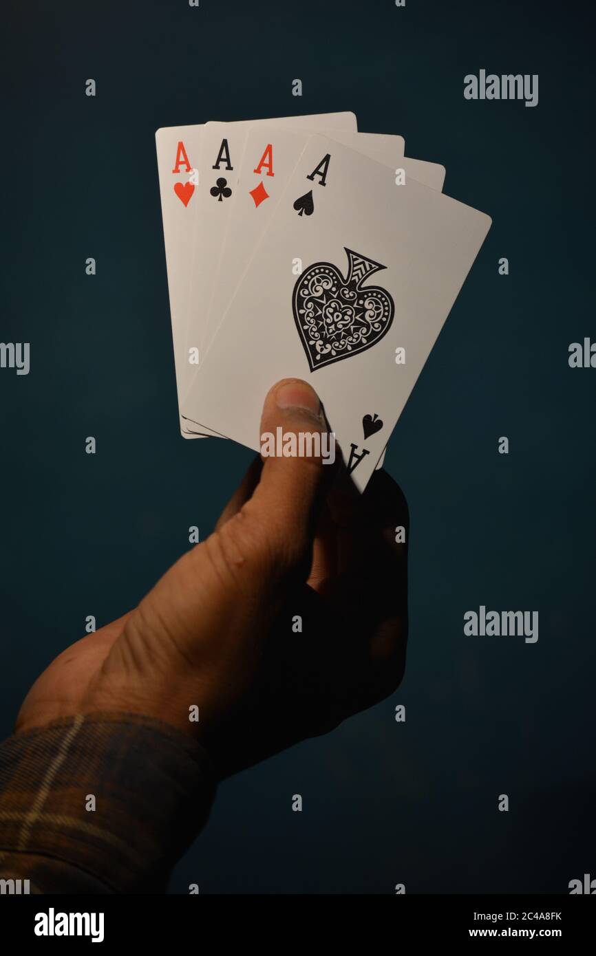 TIKAMGARH, MADHYA PRADESH, INDIA - 15 DICEMBRE 2019: Mano che tiene quattro assi che giocano carte, quattro di genere. Foto Stock
