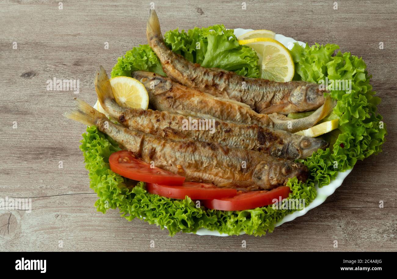 Osmerus eperlanus. Pesce fritto con lattuga, limone e pomodori Foto Stock