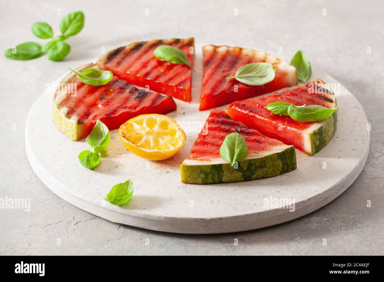 fette di anguria grigliate con limone e basilico. dessert estivo Foto Stock
