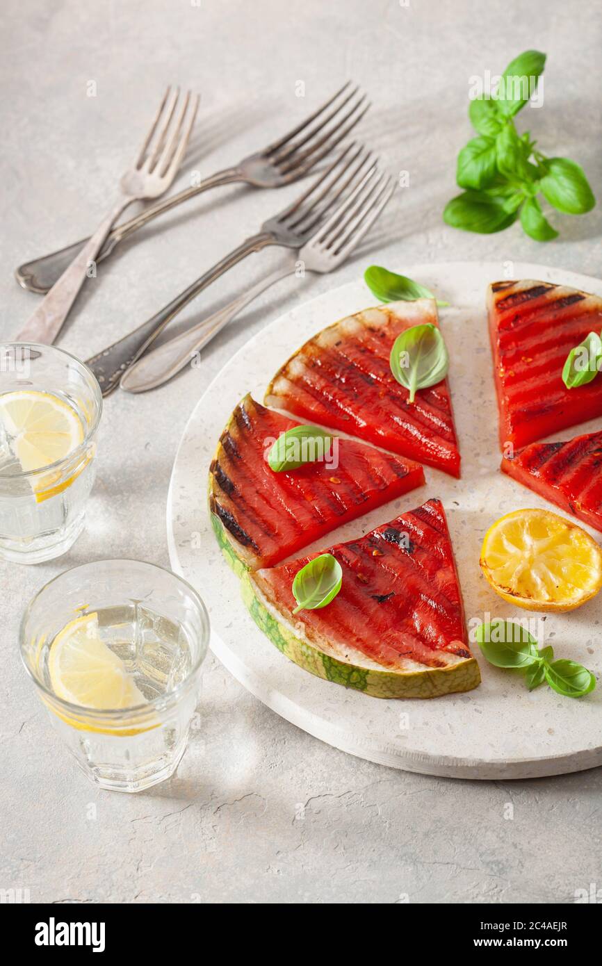 fette di anguria grigliate con limone e basilico. dessert estivo Foto Stock