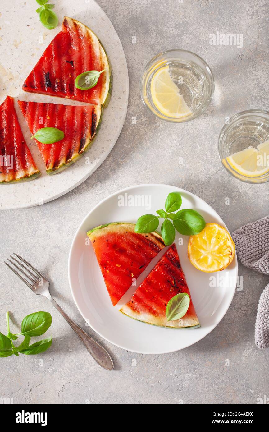 fette di anguria grigliate con limone e basilico. dessert estivo Foto Stock