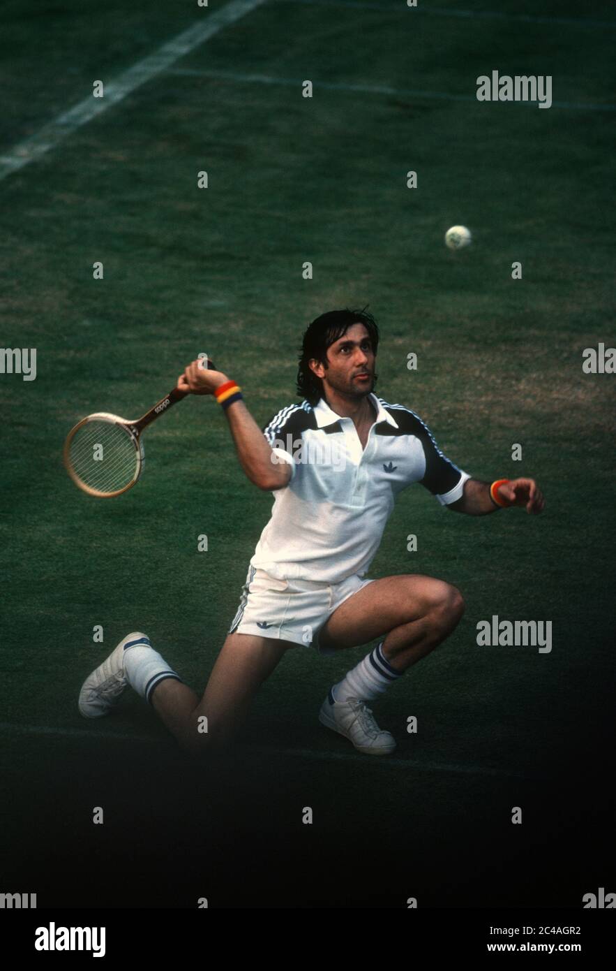 Ilie Nastase inginocchiato mentre ritorna un colpo sul Tribunale numero uno a Wimbledon, 1980 Foto Stock