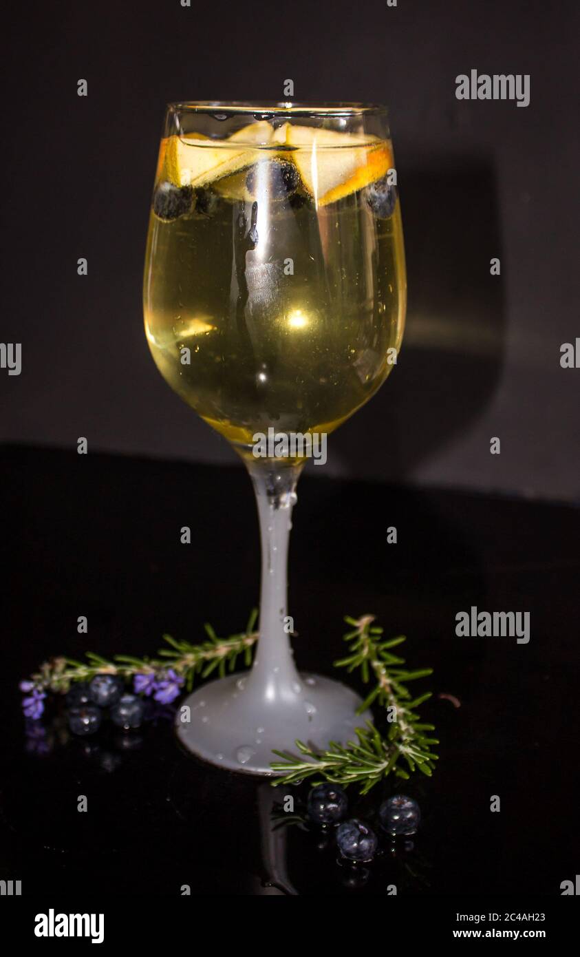 Un sangria bianco, fatto con vino bianco, succo di mela, mele fresche e mirtilli, su sfondo nero Foto Stock