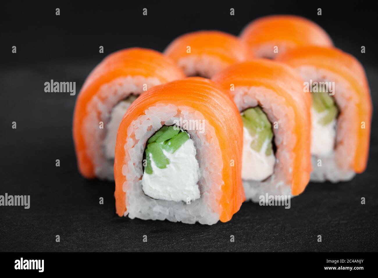 Porzione di fresco sushi roll philadelphia su sfondo nero Foto Stock