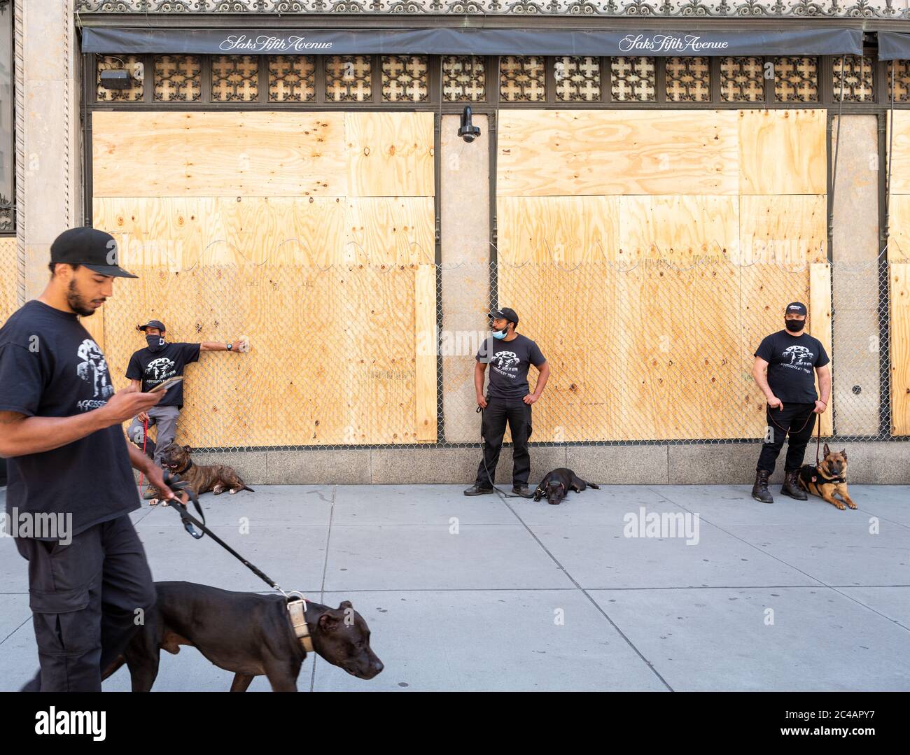 Manhattan, New York, USA - 7 giugno 2020: Saks Fith Avenue Flagship storefront coperto di legno compensato e filo di barbwire; protetto da sicurezza privata. Foto Stock