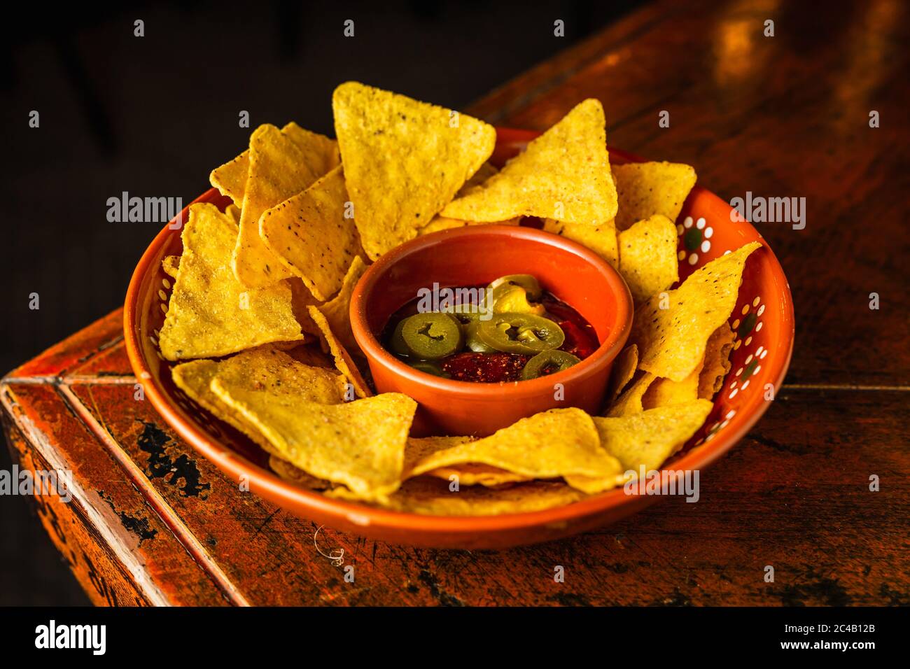 Un piatto di nachos con salsa di pomodoro e pepe di jalapeno Foto Stock