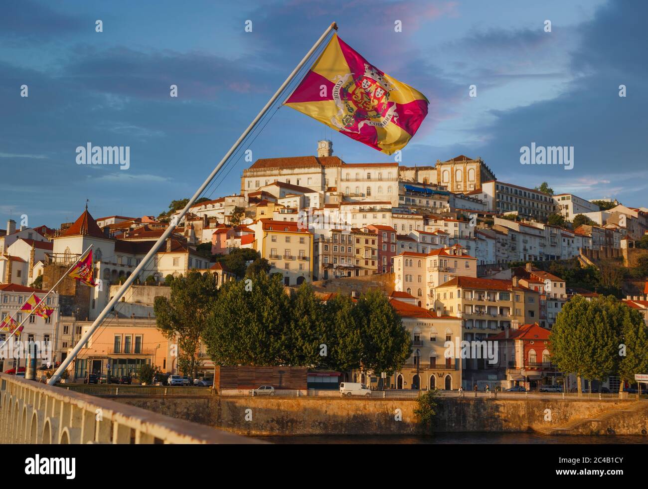 Coimbra, Portogallo visto attraverso il fiume Mondego. La bandiera è della città di Coimbra. Foto Stock