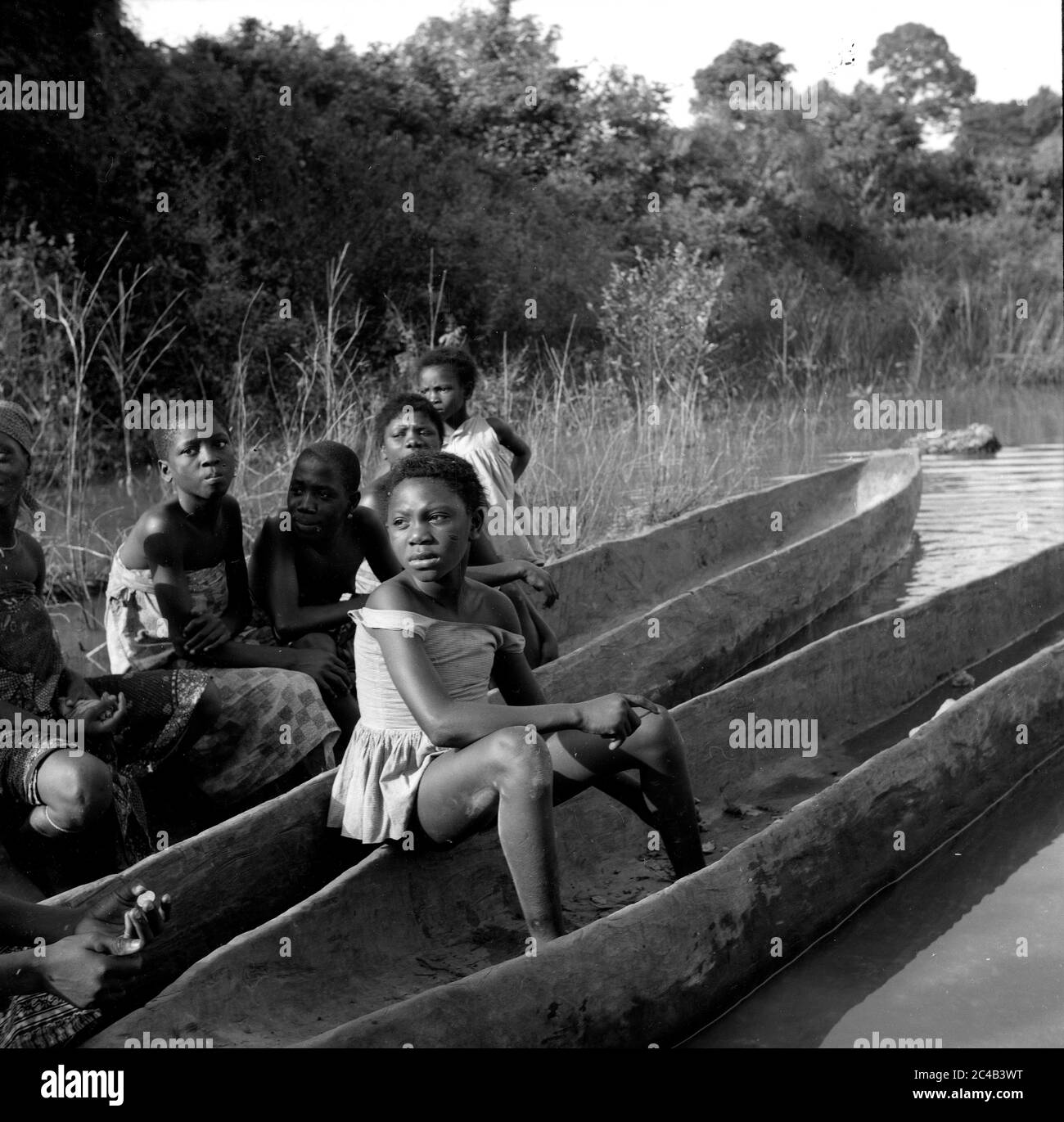 Bambini dell'Africa occidentale in canoa dugout Costa d'Avorio Costa d'Avorio anni '60 Foto Stock