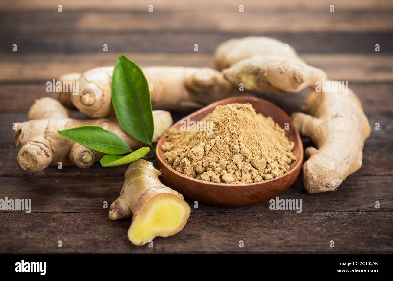 Radice di zenzero e polvere di zenzero nel recipiente Foto Stock