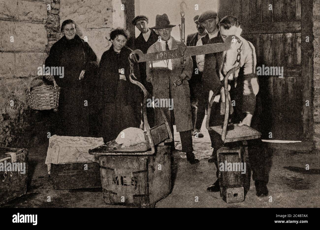 Una scena dei primi anni '20 nel mercato del burro nel quartiere Shandon di Cork City, dove una famiglia agricola ha appena portato i prodotti della settimana. Originariamente fotografato da Clifton Adams (1890-1934) per 'Ireland: The Rock Whence i was hewn', una rivista nazionale di geografia dal marzo 1927. Foto Stock