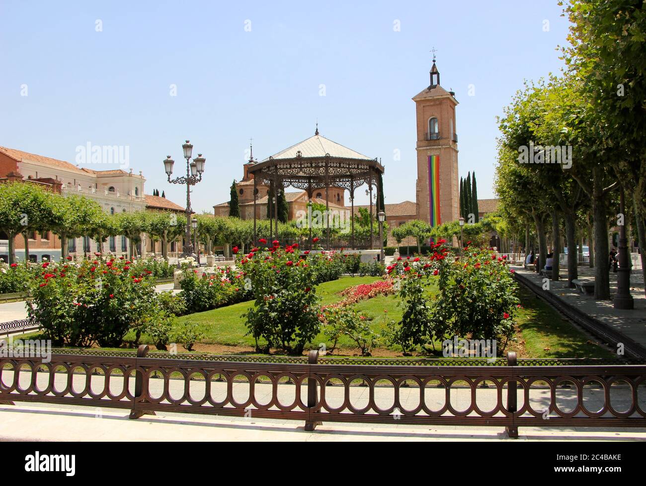 Alcala de Henares lungo banner per la settimana gay orgoglio appeso alla torre del chuch di Santa Maria Torre de la iglesia de Santa Maria e giardini Foto Stock