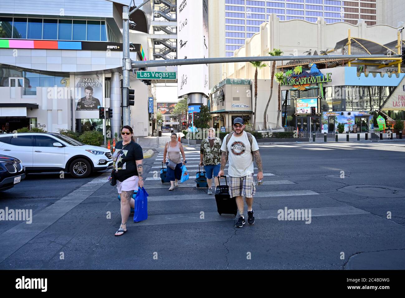 Las Vegas, Nevada, Stati Uniti. 25 Giugno 2020. I turisti senza maschere facciali camminano lungo la Strip di Las Vegas in mezzo alla diffusione del coronavirus il 25 giugno 2020 a Las Vegas, Nevada. Mercoledì, Nevada Gov. Steve Sisolak ha firmato una direttiva che impone alle persone di indossare rivestimenti per il viso in luoghi pubblici in tutto lo stato a partire dal 26 giugno in risposta a una tendenza di quattro settimane in aumento di nuovi casi COVID-19 quotidiani. Il governatore ha anche citato un aumento delle ospedalizzazioni confermate e sospette COVID-19, poiché lo Stato è entrato nella seconda fase del piano di riapertura dello Stato il 29 maggio come motivo del mandato. (Rosso Foto Stock