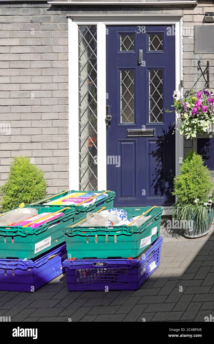 Coronavirus supermercato casa alimentare drogheria online shopping ordine consegna in casse di colore blu porta anteriore per il proprietario di casa per disimballare sacchi di plastica UK Foto Stock