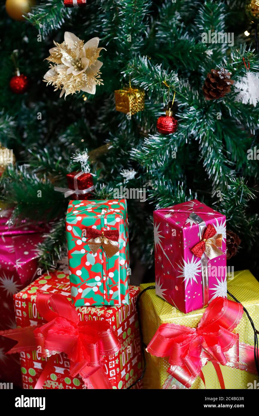 Presenta sotto l'albero di natale artificiale decorato Foto Stock