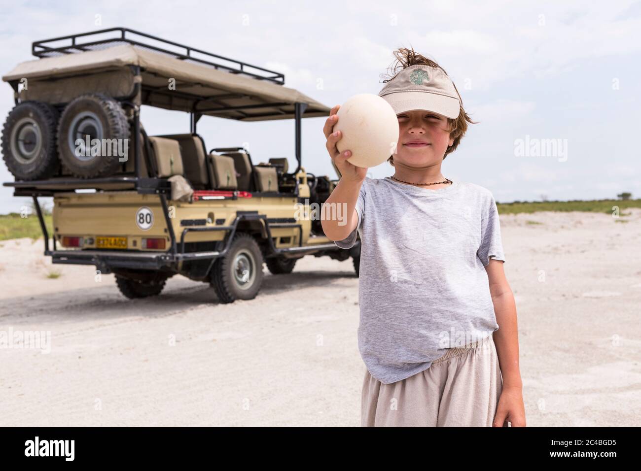 Ragazzo che tiene un uovo di struzzo grande Foto Stock