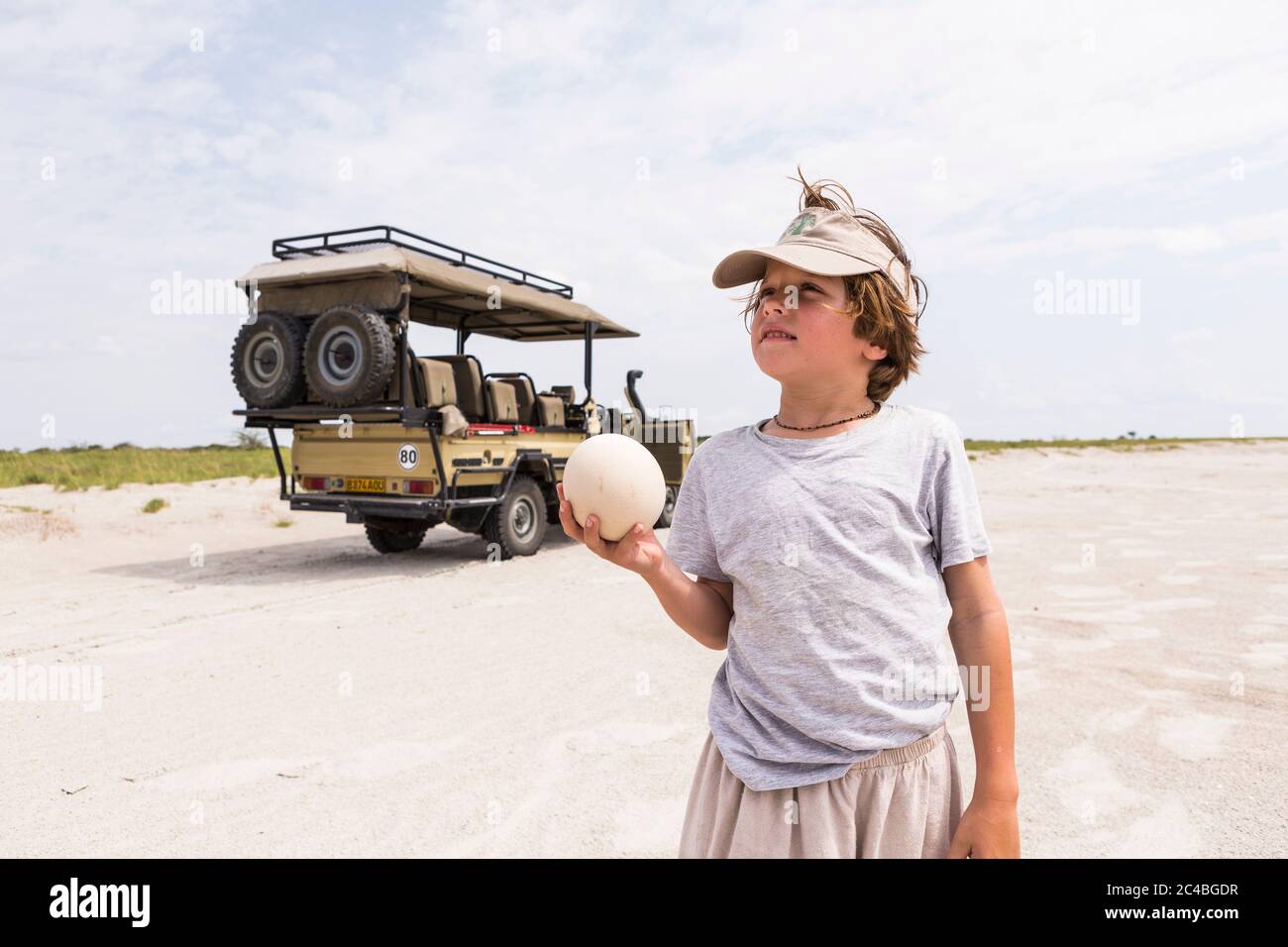 Ragazzo che tiene un uovo di struzzo grande Foto Stock