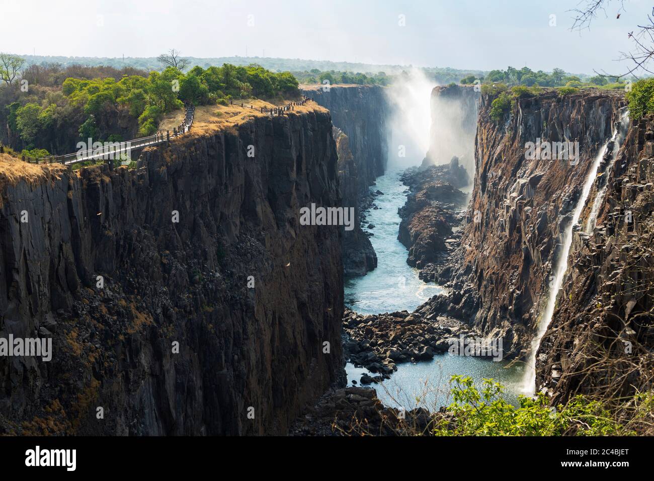 Cascate Victoria vista dal lato Zambiano, gola profonda con lati verticali, cascata con torrenti di acqua bianca. Foto Stock