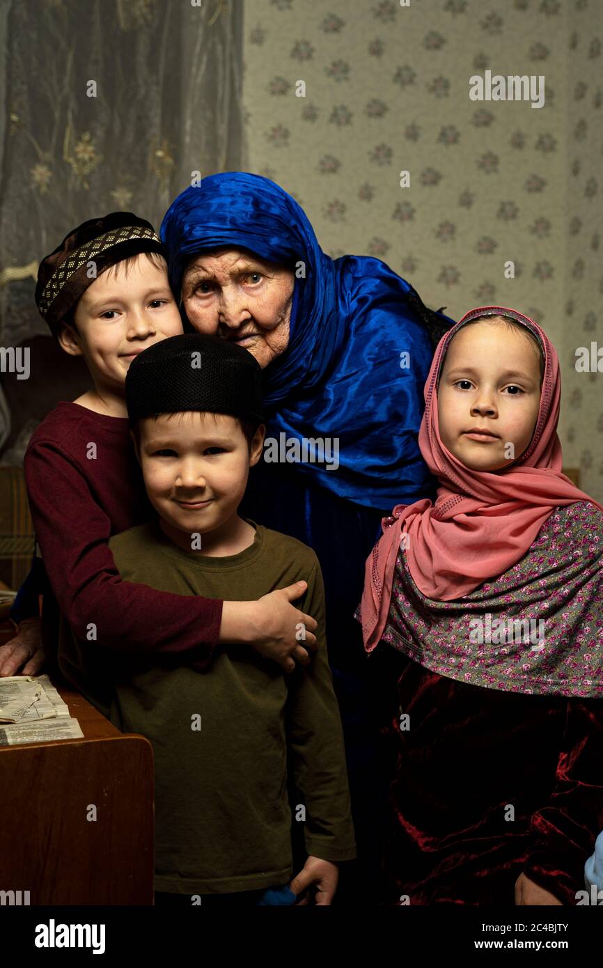 Vecchia nonna musulmana in hijab e nipoti musulmani Foto Stock