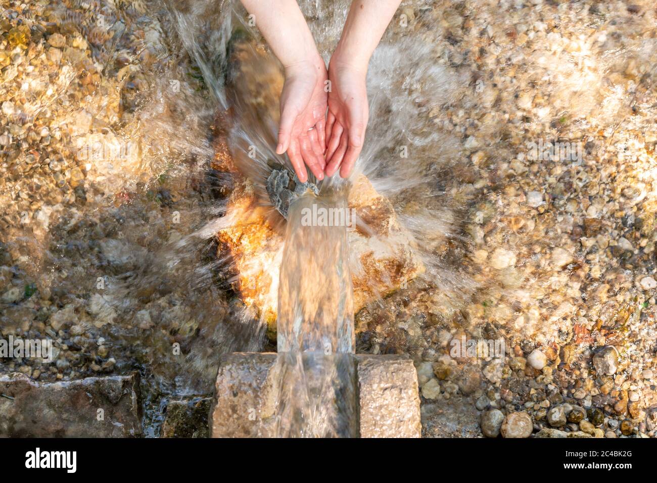 mani in acqua su vera primavera nella natura Foto Stock