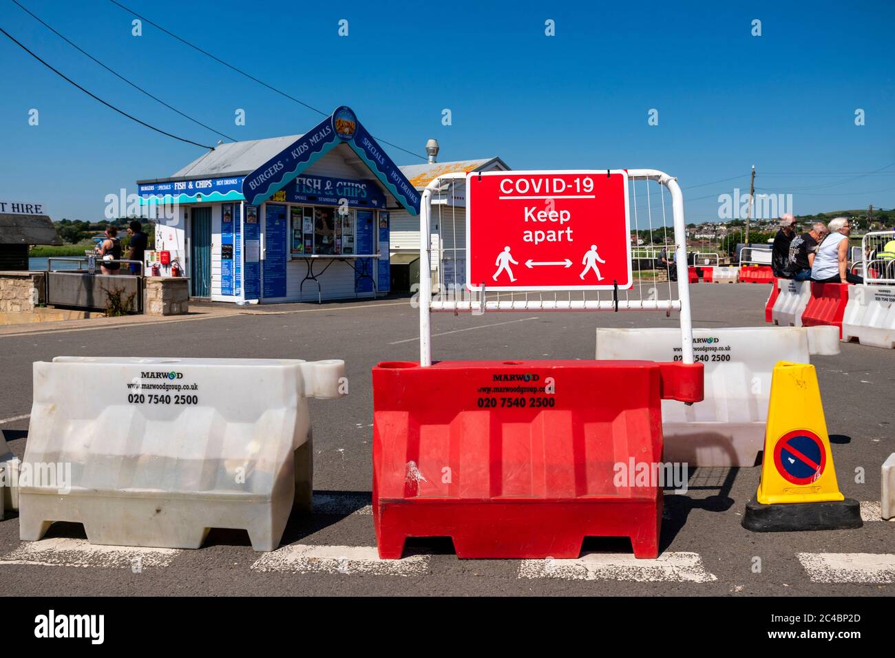 Covid-19, dove la strada è stata chiusa per fare spazio a persone che si accodano a capanne di cibo mare, West Bay, Dorset, UK. Foto Stock